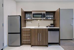 a kitchen with a refrigerator and a microwave at Home2 Suites By Hilton Salem in Salem