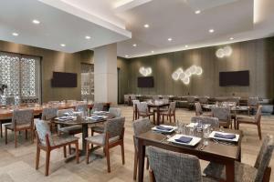 a dining room with tables and chairs and televisions at Embassy Suites by Hilton Atlanta Midtown in Atlanta