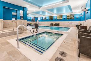 a swimming pool in a hotel lobby with blue walls at Hampton Inn & Suites Tigard in Tigard