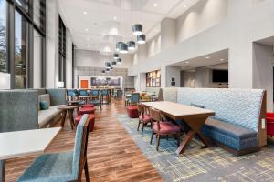 a lobby with tables and chairs and a cafeteria at Hampton Inn & Suites Tigard in Tigard