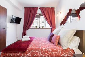 - une chambre avec un grand lit et des rideaux rouges dans l'établissement Cool Flat - City Center near Aliados, à Porto