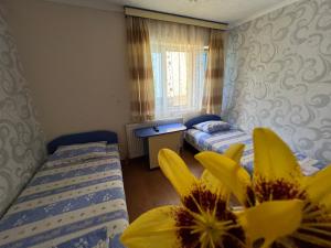 Cette chambre comprend 2 lits et une fleur jaune. dans l'établissement Vacation Home Yoanna, à Tryavna