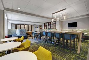 un hall avec des tables et des chaises ainsi qu'un bar dans l'établissement Hampton Inn Cave City, KY, à Cave City