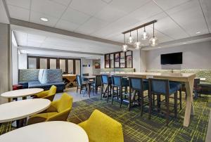 a lobby with tables and chairs and a bar at Hampton Inn Cave City, KY in Cave City