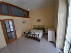 Schlafzimmer mit einem Bett, einem Fenster und einer Tür in der Unterkunft Civico 32 in Molfetta