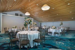 a banquet room with tables and chairs with flowers on them at The Belamar Hotel Manhattan Beach, Tapestry by Hilton in Manhattan Beach