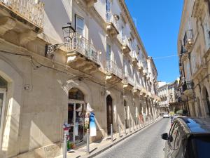 a street with buildings and a car parked on the street at Casa Igea in Siracusa