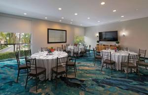 a banquet room with tables and chairs and a flat screen tv at The Belamar Hotel Manhattan Beach, Tapestry by Hilton in Manhattan Beach