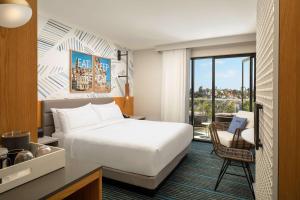 um quarto de hotel com uma cama, uma secretária e uma cadeira em The Monsaraz San Diego, Tapestry Collection By Hilton em San Diego