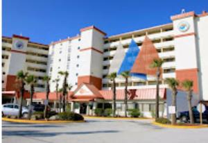 a large building with a parking lot in front of it at Oceanfront Oasis in Daytona Beach
