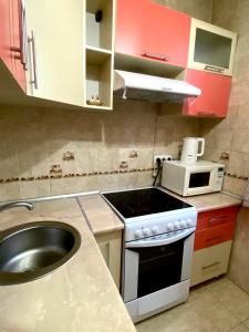 a small kitchen with a stove and a sink at Майлина 10 аэропорт in (( Turksib ))