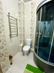 a bathroom with a toilet and a glass shower at Майлина 10 аэропорт in (( Turksib ))