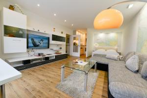uma sala de estar com um sofá e uma televisão em Strandhochhaus SHC3 em Cuxhaven