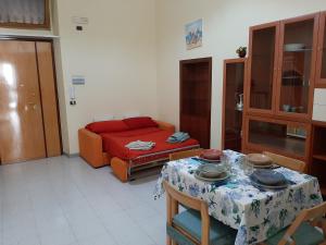 ein Wohnzimmer mit einem Tisch und einem Sofa in der Unterkunft Civico 32 in Molfetta