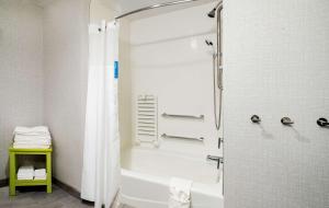 a bathroom with a shower and a white tub at Hampton Inn Riverside March Air Force Base, Ca in Riverside