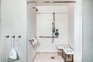 a white bathroom with a shower and a sink at Hampton Inn Riverside March Air Force Base, Ca in Riverside