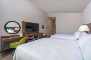 a hotel room with two beds and a mirror at Hampton Inn Riverside March Air Force Base, Ca in Riverside