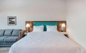 a bedroom with a large bed and a couch at Hampton Inn Riverside March Air Force Base, Ca in Riverside