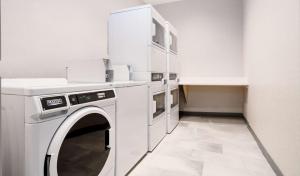 a white laundry room with a washer and dryer at Hampton Inn Riverside March Air Force Base, Ca in Riverside