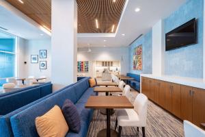 una sala de espera con mesas y un sofá azul en Homewood Suites By Hilton Sunnyvale-Silicon Valley, Ca, en Sunnyvale