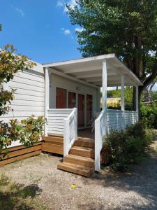 a small white house with a porch and stairs at Camping Taimì in Marina di Massa