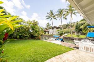 a backyard with a lawn and a swimming pool at Unique Boathouse on the Bay in Kaneohe