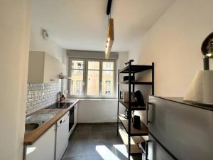 a kitchen with a sink and a refrigerator at Appartement Rubis - 2 pers - Sedan in Sedan