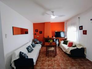 sala de estar con 2 sofás y TV en Casa Rural Agua de Azahar Chimenea, en Zahara de la Sierra