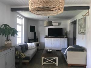 a living room with a couch and a tv at Maison jardin 3 ch centre ville Bassin Arcachon in Audenge