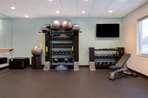 a room with a gym with a television and weights at Tru By Hilton Macon North, Ga in Macon