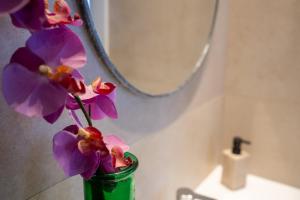 um vaso verde com flores roxas numa casa de banho em Villa JAS San Juan em La Venteta