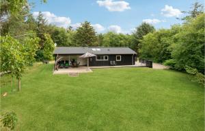 ein Haus mit einem großen Garten davor in der Unterkunft Strandbo in Thyholm