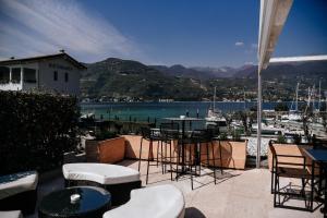 a patio with tables and chairs and a view of a harbor at Bella Hotel & Restaurant with private dock for mooring boats in San Felice del Benaco