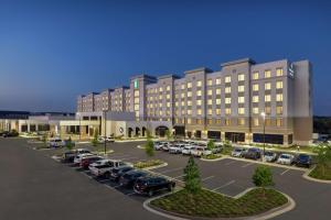 圆石城Embassy Suites by Hilton Round Rock的一座大楼，停车场里停满了汽车