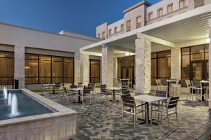 a patio with tables and chairs next to a building at Embassy Suites by Hilton Round Rock in Round Rock