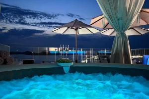 - une piscine avec parasols la nuit dans l'établissement Murter Luxury Penthouse with Sea View for two, à Murter