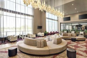 hol z kanapami i krzesłami oraz żyrandolem w obiekcie Embassy Suites by Hilton Round Rock w mieście Round Rock