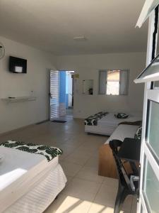 - une chambre avec deux lits et une chambre avec un bureau dans l'établissement Suítes Praia Martin de Sa, à Caraguatatuba