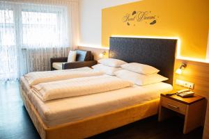 サン・ヴァレンティーノ・アッラ・ムータにあるGarni Apparthotel St Valentinの大きなベッドと椅子が備わるホテルルームです。