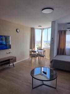 una sala de estar con una cama y una mesa en סוויטת הנופש שלי נגיעה מהים, en Eilat
