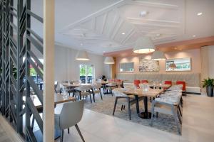 a dining room with tables and chairs in a restaurant at Hilton Garden Inn Panama City Airport, Fl in Panama City