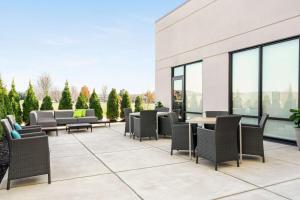 un patio avec des chaises et des tables dans un bâtiment dans l'établissement Hampton Inn & Suites Olean, Ny, à Olean