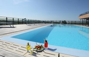 a large swimming pool with blue water at Grand Hotel Forlì in Forlì