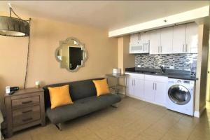 uma sala de estar com um sofá e uma máquina de lavar roupa em KING BED, Spacious, Legal, VIEW em Honolulu