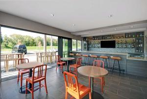 a restaurant with tables and chairs and a bar at Home2 Suites by Hilton Blacksburg University in Blacksburg