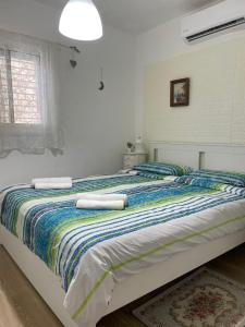 a bedroom with a large bed with towels on it at דירה נעימה ומפנקת באזור יפו in Tel Aviv