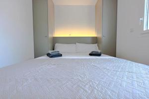 a large white bed with two phones on top of it at CAN ROMY APPARTEMENT T3 B - à 20m de la plage de Cala Montgo in L'Escala