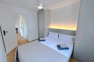 ein Schlafzimmer mit einem weißen Bett mit zwei Handtüchern darauf in der Unterkunft T3 B - Best place in Cala-Montgo beach Appartment with 3 beds, Air Conditioner & private parking in Torroella de Montgrí