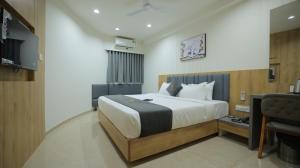 a bedroom with a large bed and a television at Hotel Shayan Inn in Rajkot