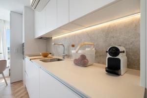 a kitchen with a sink and a toaster on a counter at Hauzify I Loft Ancora in La Pineda +8 photos